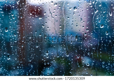 Raindrops on window glass. Selective focus. Rainy city background