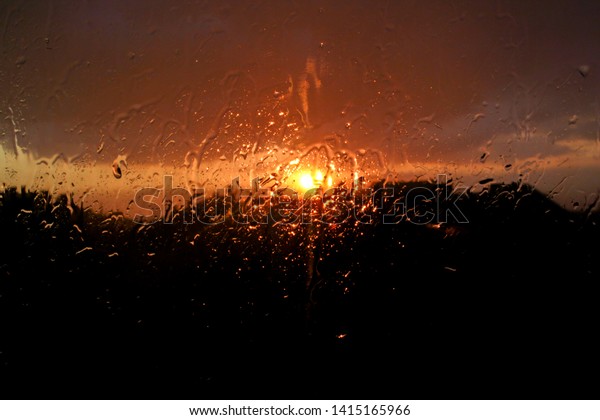 raindrops on window\
glass through the\
sunset