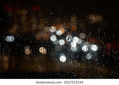 Raindrops on a window at night. Rain drops on glass window with night city lights on background, close-up - Powered by Shutterstock