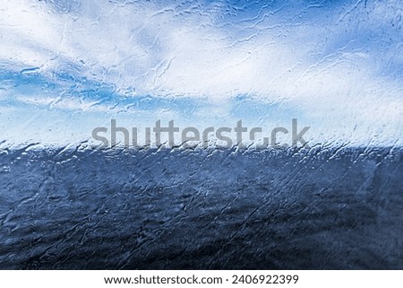 Raindrops on the window overlooking the sea. Background with sea and sky on a rainy day. 