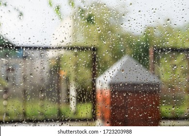 Raindrops On The Window Pane. Blurred Background Outside The Window In The Rain.