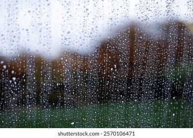 Raindrops on a window pane on a blurred colored background