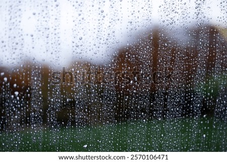 Raindrops on a window pane on a blurred colored background