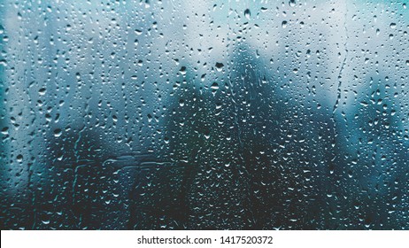 raindrops on a window. Rainy window at night. Drops on the black glass. dark blue wet, drops of water rain on glass background. concept of autumn weather. - Powered by Shutterstock