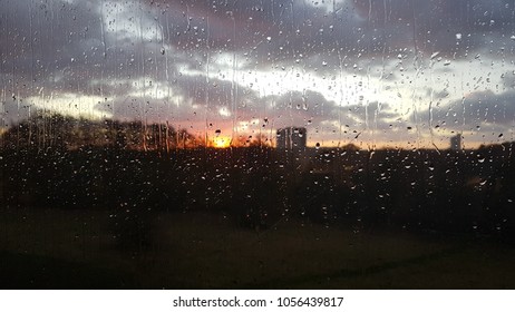 Raindrops on window in sunset