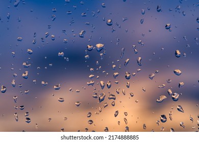 Raindrops on a window with a sunset sky in the background. Clear weather after the rain. - Powered by Shutterstock