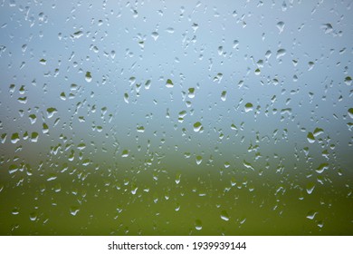 Raindrops On A Windowpane With Indistinct Shapes And Colours Behind. Giving A Sense Of Being Stuck Indoors Or Depressed.