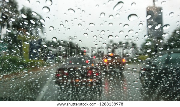 Raindrops on the windshield while driving on a rainy\
day, 