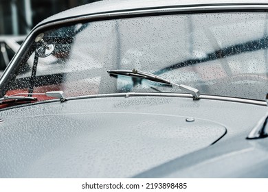 Raindrops On The Windshield And Working Wipers Of A Retro Car. Cinematic And Atmospheric Mood Of The Picture