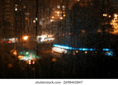 Raindrops slowly trailing down window while blurred city lights shine in distance through the night. Concept of loneliness, emotional silence, unseen presence in rainy solitude