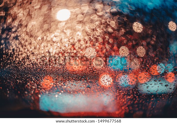 Raindrops that adhere to the windshield that\
is parked in the midst of a traffic\
jam