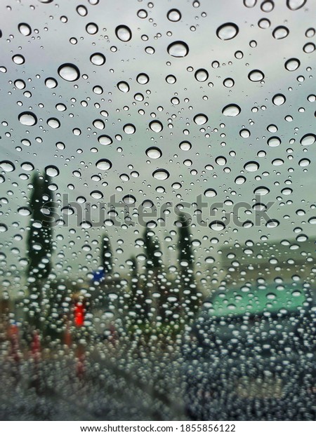 Raining day, focusing the rain\
drop on window glass. Abstract background texture without green\
tree  background focus gives romantic feeling. Rainy\
season.
