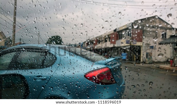 raining day with raindrops on car glasses,\
selective focus