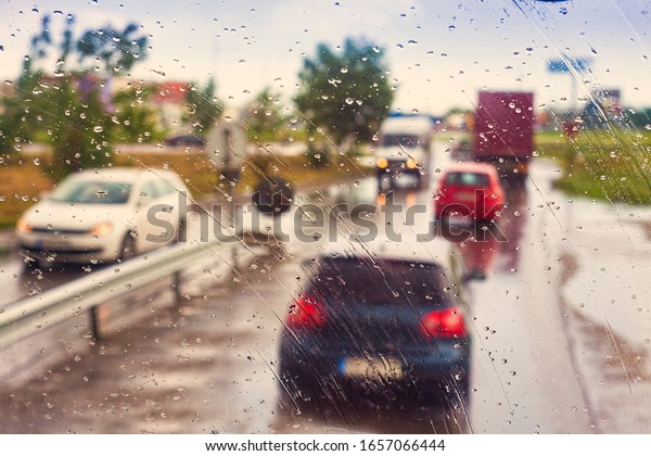 raining on the window of car. cars on the road,\
transportation concept