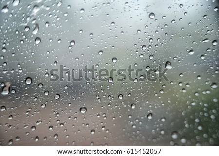 raining outside the car while driving   , rainyday , raindrops on the car glass  , blur view 