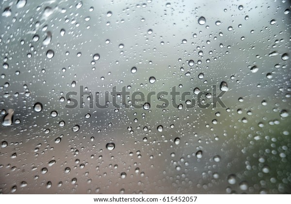 raining outside the car while driving\
  , rainyday , raindrops on the car glass  , blur view\

