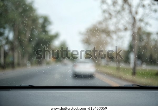 raining outside the car while driving  \
, rainyday , raindrops on the car glass   blur\
view