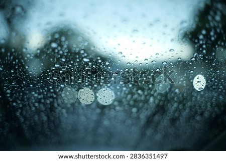 raining outside the car while driving,raindrops on the car glass, water drop front car on rainyday.