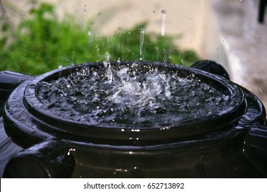 Rainwater Harvesting During Monsoon Rains. Rainwater Being Collected In A Black Plastic Water Tank, Overhead Composition. Water Day.