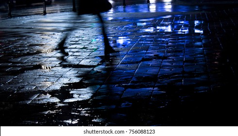 Rainy City Street Reflections: Legs Of A Young Woman Walking In The Night