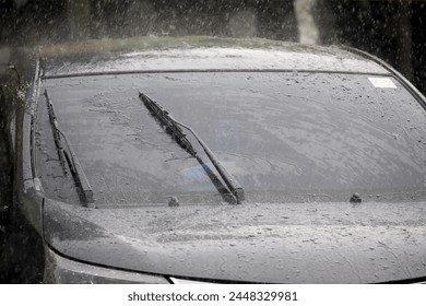 rainy day, car wipers sweep rain water on car windshield, driving in heavy rain - Powered by Shutterstock