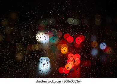 rainy days.rain falling on the window surface and traffic bokeh light in background