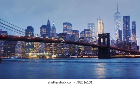 Rainy Manhattan and the Brooklyn Bridge. The tops of the skyscrapers in clouds drown. Night comes to the business district of New York, the lights. There is rain, heavy fog - Powered by Shutterstock