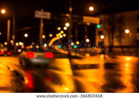 Rainy night in the big city, cars traveling on wet highway. Defocused image