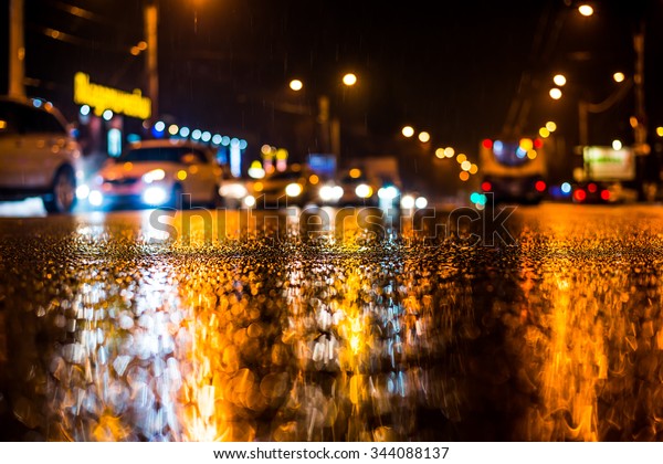Rainy
night in the big city, dense traffic at a busy avenue in the light
of shop windows. View from the level of
asphalt