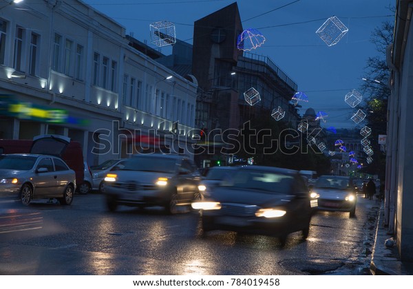 Rainy night in the big city. Headlights in dark\
street. Night traffic, cars on highway road on sunset evening night\
in busy city