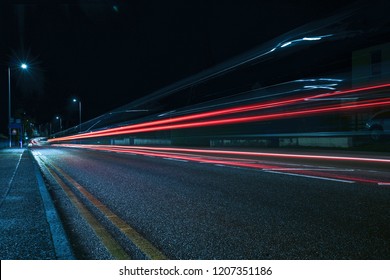 Rainy night in the big city, light from the shop windows reflected on the road on which cars travel. View from the level of asphalt - Shutterstock ID 1207351186