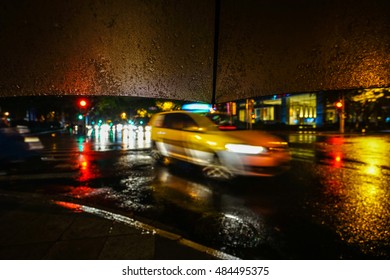 Rainy night. Close up view of the drop on the umbrella during rain.City life in night in rainy season abstract background.