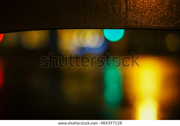 Rainy\
night. Close up view of the drop on the umbrella during rain.City\
life in night in rainy season abstract\
background.
