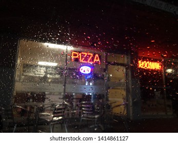 Rainy Night In Front Of Pizza Shop.