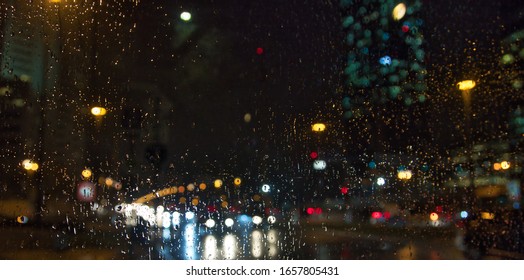 rainy night ,rain drops on window surface.traffic bokeh light in  distance  - Powered by Shutterstock