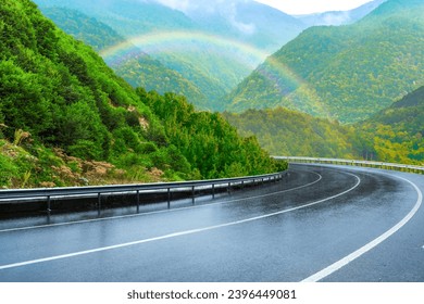 rainy road landscape in green mountains. Highway view on rainy winter day. Nature scenery on rainy highway with high mountains. Beautiful road trip in winter season. rainbow scene on european roads. - Powered by Shutterstock