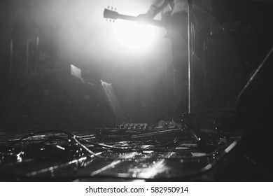 Rainy Stage Flore With The Guitar Gear And Microphone And Guitarist At Background In A Backlights