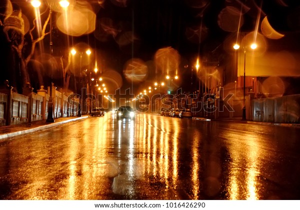 The rainy streets of Baku . Rainy night\
in the Baku city, the cars headlights shine through the mist. Close\
up view from the level of the dividing\
line