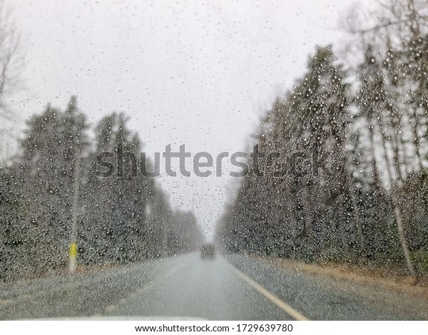 Rainy weather on highway, rain drops on the\
windshield. Abstract cars, blurred backdrop.Dangerous vehicle\
driving in the heavy rainy and slippery road. Abstract blurred bad\
weather car on the\
highway.