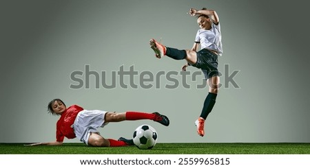 Rainy weather training session. Powerful action of two female soccer players in middle of intense play, competing for the victory. Concept of sport, action, competition, game. Copy space