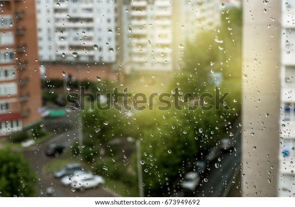 Rainy\
window Blurred building sky and cars Rainy weather\
