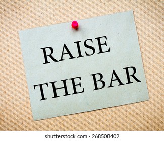 Raise The Bar Message. Recycled Paper Note Pinned On Cork Board. Concept Image