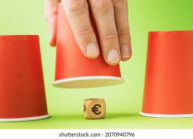 A Raised Glass And A Wooden Cube With A Euro Symbol Underneath, The Concept Of Thimble Gambling And Its Harm