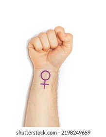 Raised Hand Making A Fist Gesture Of Power With A Feminist Feminism Logo Wrist Tattoo, Woman Power Concept Isolated On A White Background