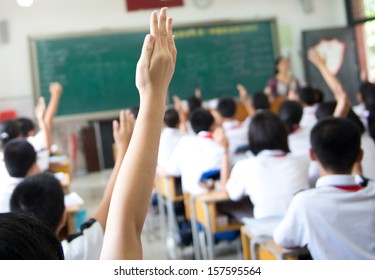 Raised hands in class of middle school. - Powered by Shutterstock