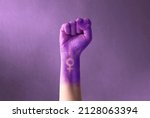 Raised purple fist of a woman for international women