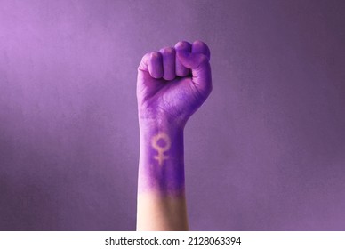Se levantó el puño morado de una mujer para el día internacional de la mujer y el movimiento feminista. 8 de marzo por el feminismo, la independencia, la libertad, el empoderamiento y el activismo por los derechos de las mujeres