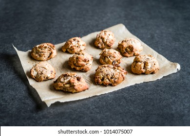 Raisin rolls on baking paper on a dark background