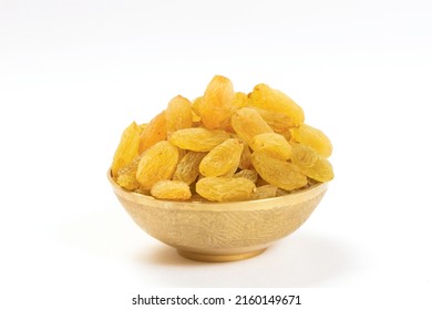 Raisins in gold metal bowl on white background, heap of raisins in gold bowl