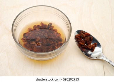 Raisins Soaked In Glass Bowl On Wooden Table